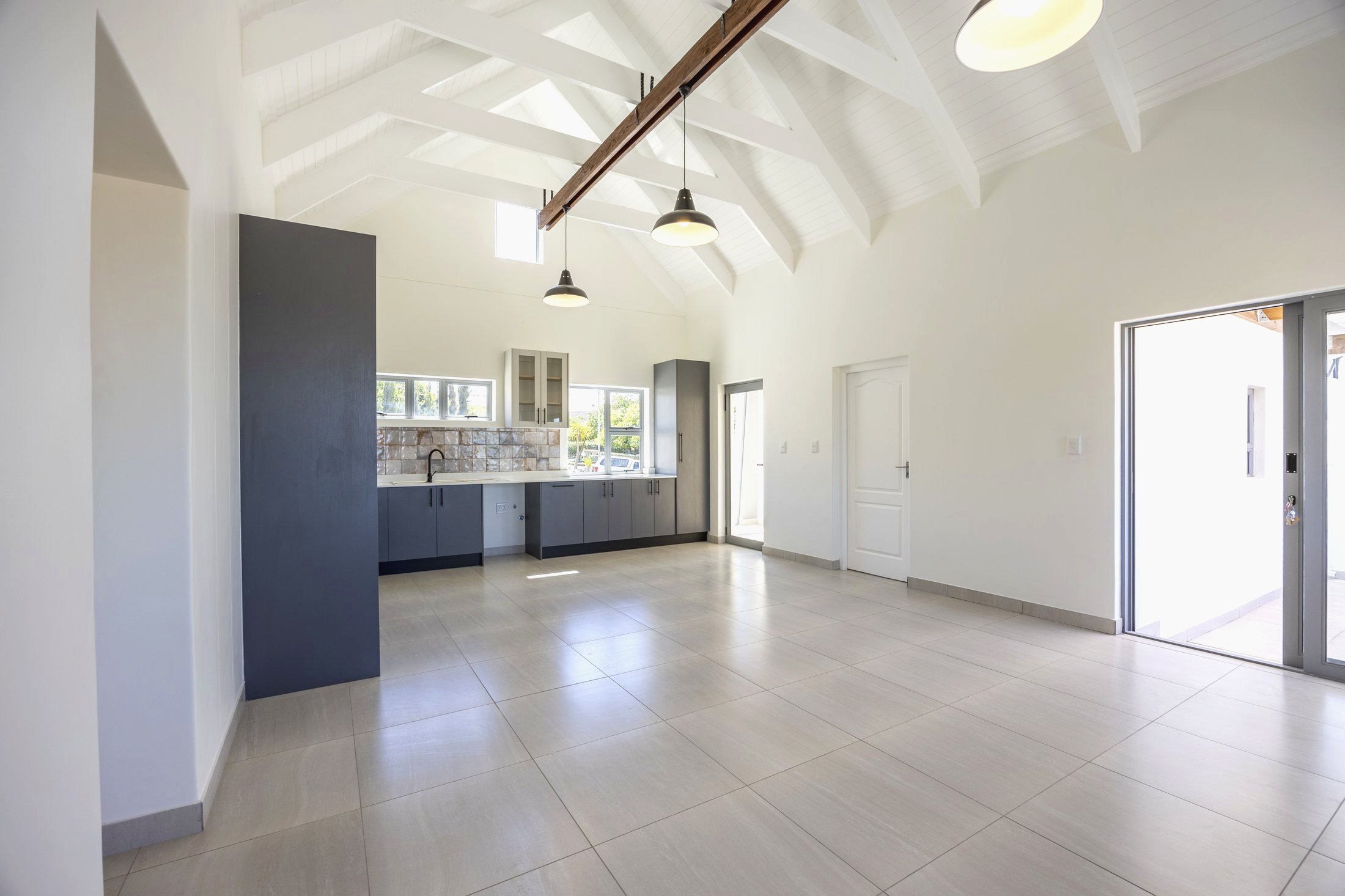 Inside a finished Welgedaan home - open-plan living with vaulted ceiling and navy cabinetry